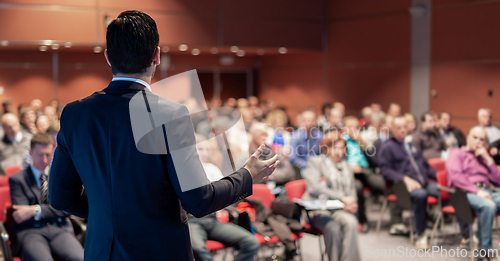 Image of Public speaker giving talk at business event.