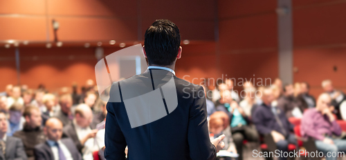 Image of Public speaker giving talk at business event.