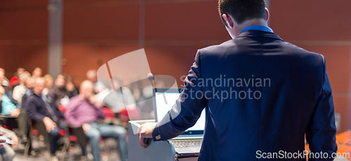 Image of Public speaker giving talk at business event.
