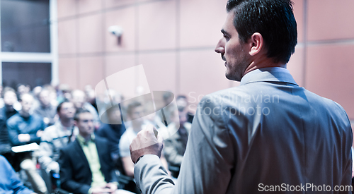 Image of Public speaker giving talk at business event.