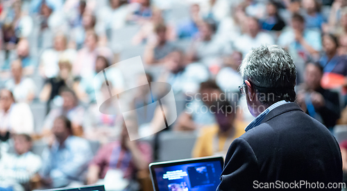 Image of Public speaker giving talk at Business Event.