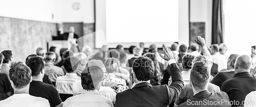 Image of I have a question. Group of business people sitting in conference hall. Businessman raising his arm. Conference and Presentation. Business and Entrepreneurship