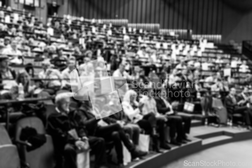 Image of Blurred, unrecognizable, business people in the audience listening to lecture in conference hall. Business and Entrepreneurship concept. Black and white image