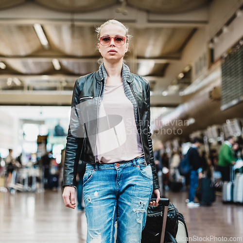 Image of Female traveller walking airport terminal.
