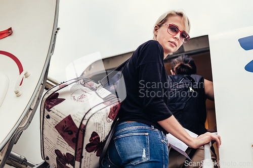 Image of Woman boarding airplane.