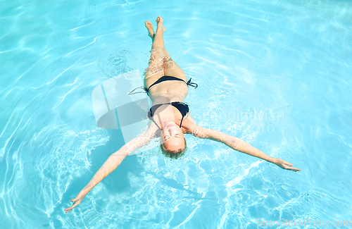 Image of Caucasian lady floating in swimming pool.