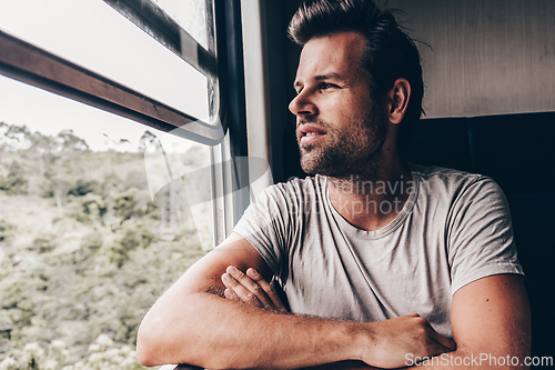 Image of Thoughtful middle age man looking out of the window of train. Male traveler during travel by train in Asia