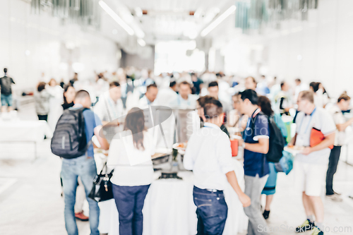Image of Abstract blurred people socializing during lunch break at business conference.