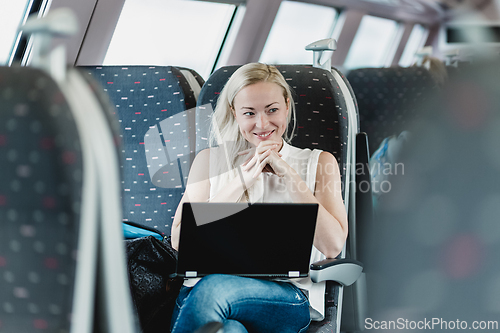 Image of Woman smiling while travelling by train.
