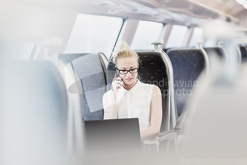 Image of Business woman working while travelling by train.