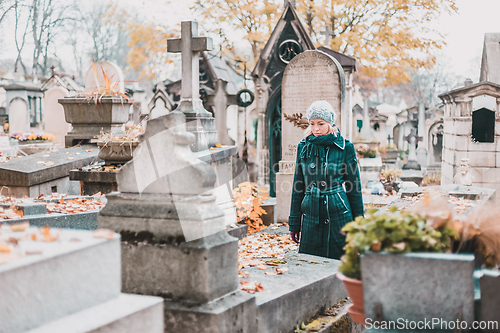 Image of Solitary woman visiting relatives grave.