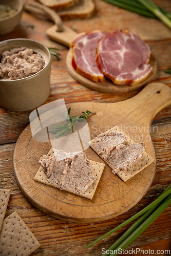 Image of Placing savory pate on crisp crackers