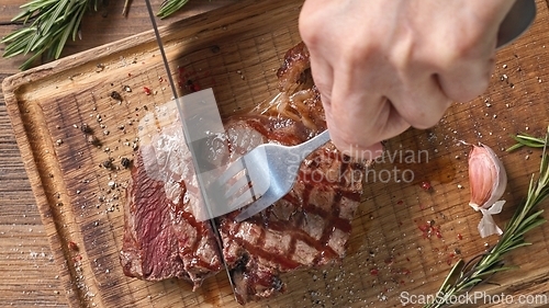 Image of Chef slicing freshly grilled juicy beef steak 