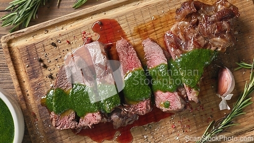 Image of freshly grilled sliced steak with green parsley sauce