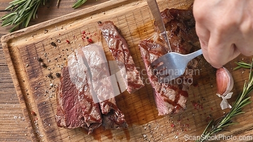 Image of Chef slicing freshly grilled juicy beef steak 