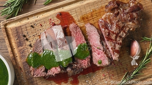 Image of freshly grilled sliced steak with green parsley sauce