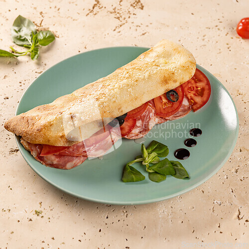 Image of Ciabatta with juicy tomatoes, olives and salami