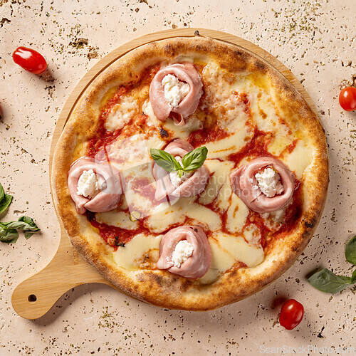 Image of Freshly baked pizza with ham and ricotta cheese