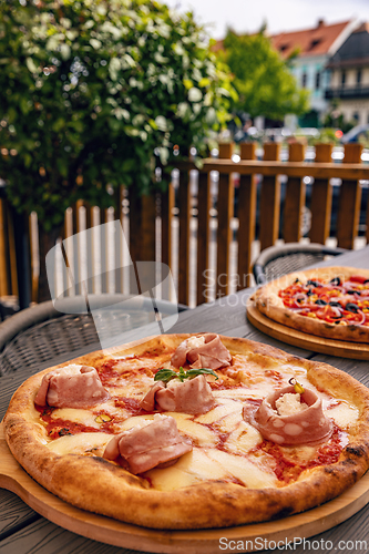 Image of Freshly baked pizza with melted cheese and meat toppings