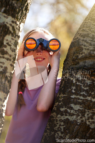 Image of Tree, girl and binoculars for safari, search and looking for animals on travel holiday. Smile, fun and seek for bird watching or wildlife in nature, happy young child and scenery or view in Kenya