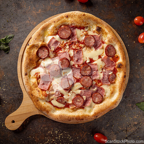 Image of Delicious pizza lying on wooden board