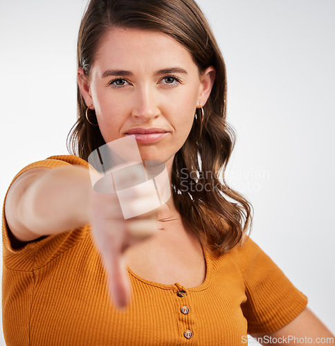 Image of Woman, portrait and thumbs down rejection in studio for vote, voice or opinion, rating or fail on white background. Face, no or model show emoji feedback, review or warning, gesture or disappointment