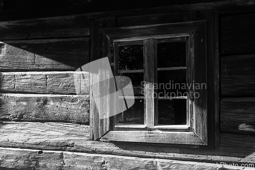 Image of Wooden village window lit by the morning sun