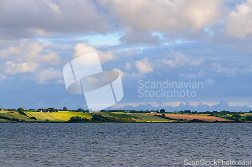 Image of Vibrant Summer Landscape With Rolling Fields Under a Dramatic Sk