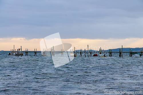 Image of Tranquil Evening at the Coastal Dock With Boats Under a Cloudy S