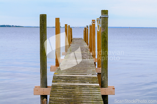 Image of Tranquil Wooden Dock Extending Over Still Waters at Dusk in a Pe