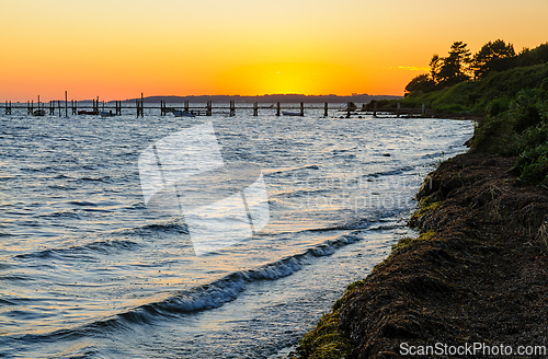 Image of Golden Sunset Over Tranquil Waters With Dock and Lush Shoreline 