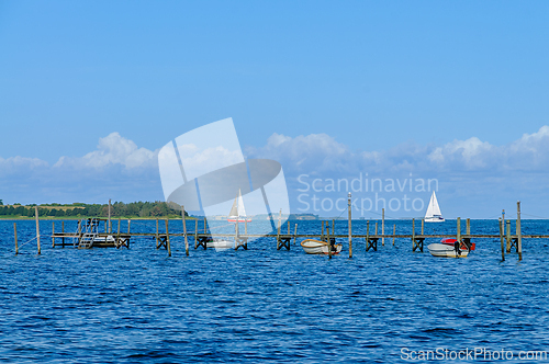Image of Tranquil Afternoon by the Waterfront With Sailboats Gliding on t
