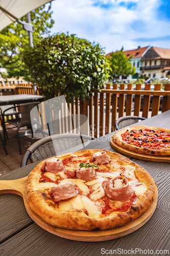 Image of Delicious pizza served on wooden plate