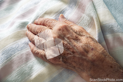 Image of Winkled hand of an 100 old senior elderly women resting peacefully on hospital bedding. Concept of life, aging, health, illness, dying, compassion, ...
