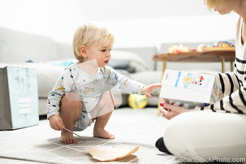 Image of Parents playing games with child. Little toddler doing puzzle. Infant baby boy learns to solve problems and develops cognitive skills. Child development concept
