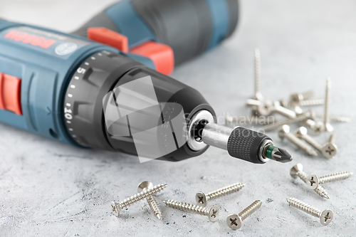 Image of Professional cordless drill screwdriver and screws close-up