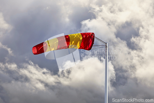 Image of Striped Windsock against Dark Cloudy Sky