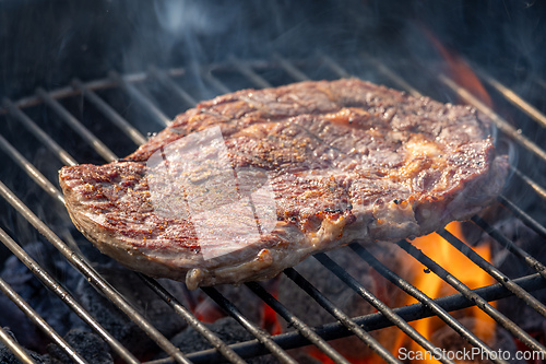 Image of steak grilling on charcoal grill