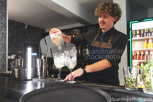 Image of Experienced mixologist expertly preparing trendy cocktails