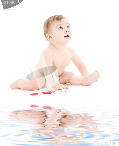 Image of baby boy in diaper with toothbrush