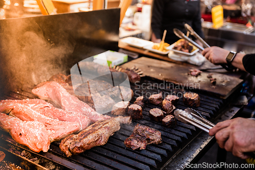Image of Some excellent pieces of Argentinian beef on a charcoal grill being prepared at open kitchen street food festival in Ljubljana, Slovenia.