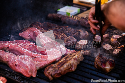 Image of Some excellent pieces of Argentinian beef on a charcoal grill being prepared at open kitchen street food festival in Ljubljana, Slovenia.