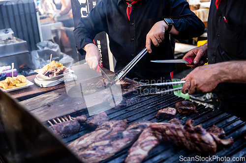 Image of Some excellent pieces of Argentinian beef on a charcoal grill being prepared at open kitchen street food festival in Ljubljana, Slovenia.