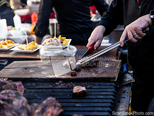Image of Some excellent pieces of Argentinian beef on a charcoal grill being prepared at open kitchen street food festival in Ljubljana, Slovenia.