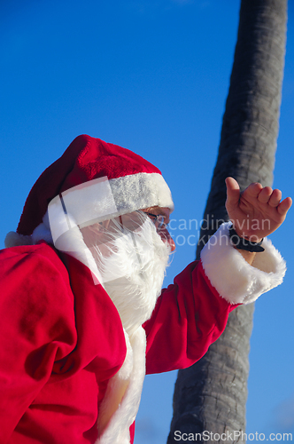 Image of Santa Claus is on vacation on a tropical beach.