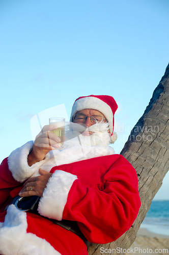 Image of Santa Claus is on vacation on a tropical beach.