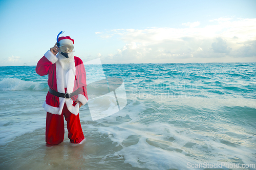 Image of Santa Claus is on vacation on a tropical beach.
