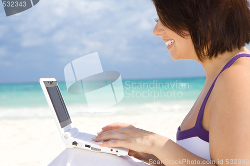 Image of woman with laptop computer on the beach