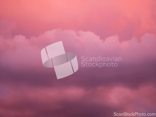 Image of Detail of redish and violet clouds on evening sky