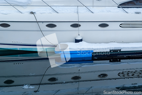 Image of A serene winter morning at the marina, where a sleek yacht rests